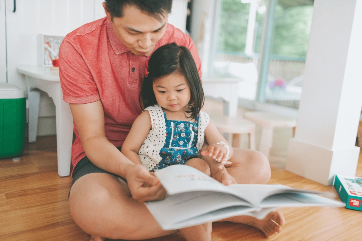 asian father reads for her daughter